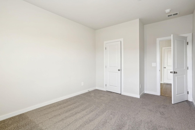 unfurnished bedroom featuring carpet, visible vents, and baseboards