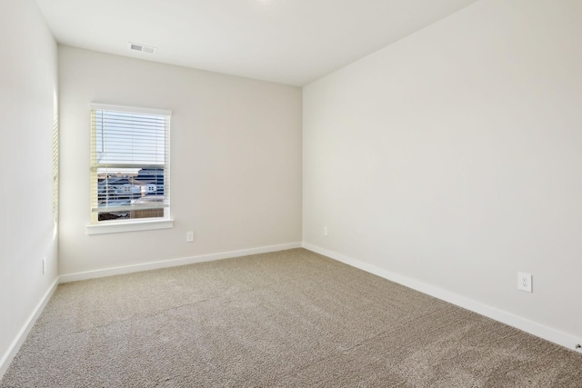 unfurnished room featuring visible vents, baseboards, and carpet