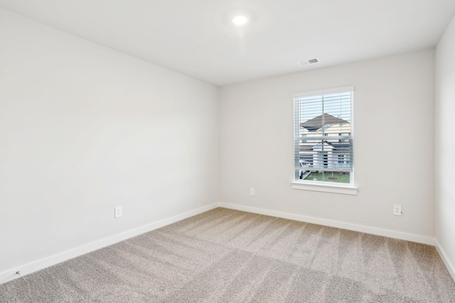 empty room with visible vents, baseboards, and carpet floors