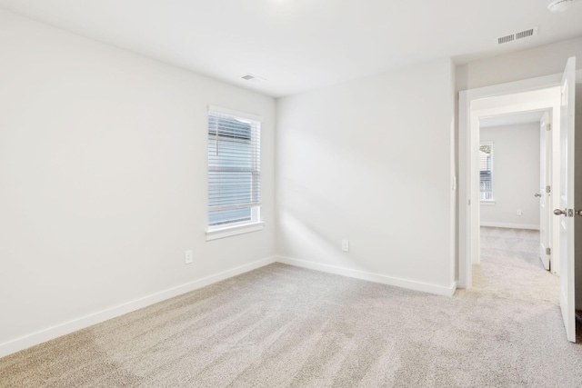 spare room with visible vents, baseboards, and carpet flooring