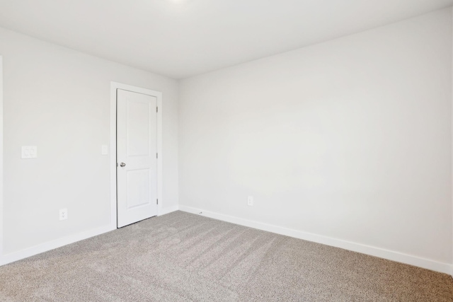 empty room featuring baseboards and carpet