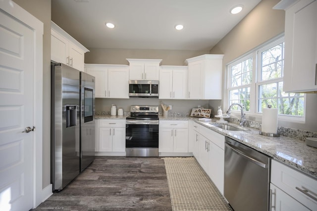 kitchen featuring sink, stainless steel appliances, light stone counters, dark hardwood / wood-style floors, and white cabinets