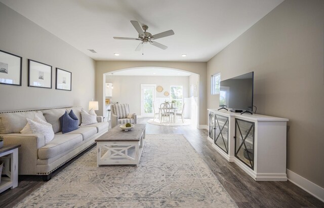 living room with dark hardwood / wood-style flooring and ceiling fan