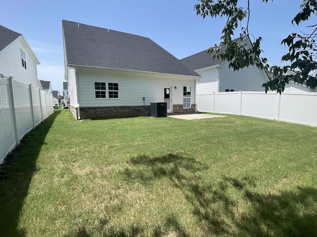 back of house with central AC unit, a yard, and a patio