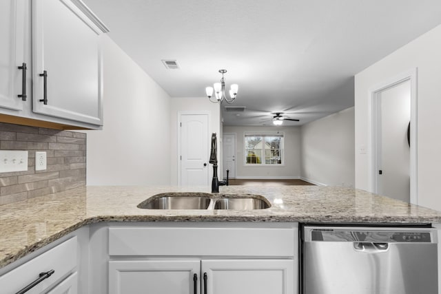 kitchen featuring white cabinets, ceiling fan with notable chandelier, sink, stainless steel dishwasher, and light stone countertops