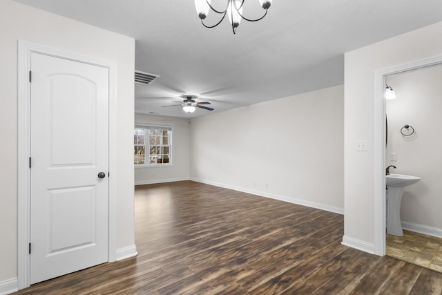 interior space with dark wood-type flooring and ceiling fan with notable chandelier