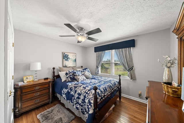 bedroom with ceiling fan, dark wood-type flooring, and a textured ceiling