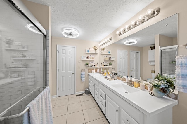 bathroom with a textured ceiling, tile patterned flooring, vanity, and an enclosed shower