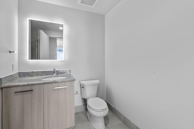 bathroom featuring toilet, vanity, and tile patterned flooring