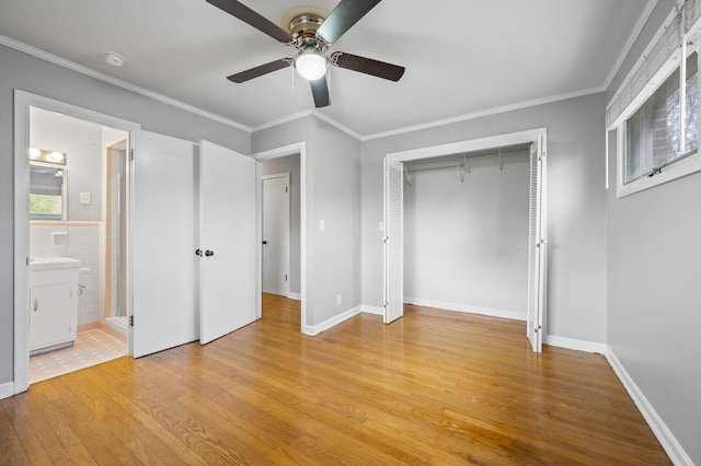 unfurnished bedroom with ceiling fan, ensuite bathroom, light hardwood / wood-style floors, a closet, and ornamental molding