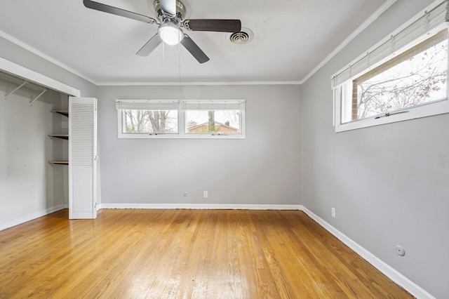 unfurnished bedroom with ceiling fan, light wood-type flooring, crown molding, and a closet