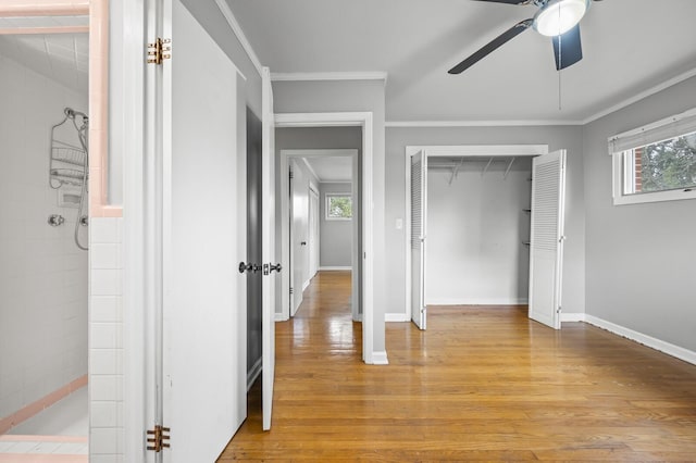 unfurnished bedroom with multiple windows, a closet, light hardwood / wood-style floors, and ceiling fan