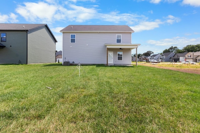 rear view of property featuring a lawn and central AC