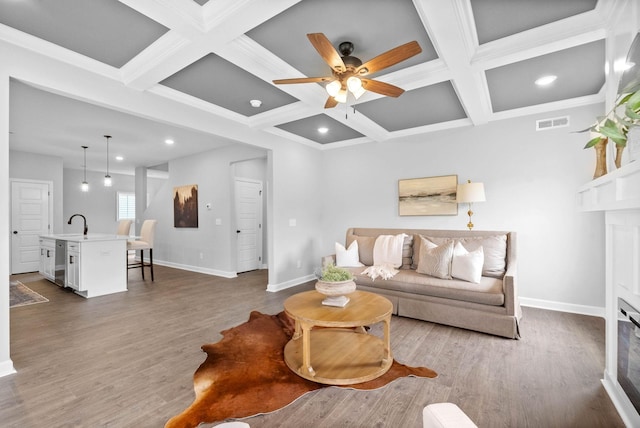 living room featuring hardwood / wood-style floors, ceiling fan, beamed ceiling, and coffered ceiling