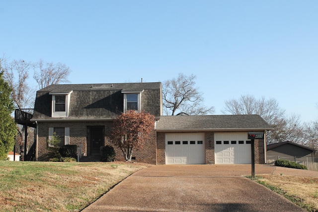 view of front of house featuring a balcony, a front lawn, and a garage