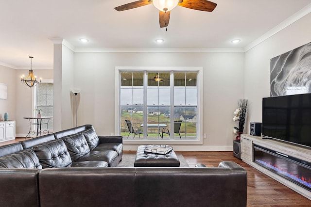 living room featuring dark hardwood / wood-style flooring, crown molding, and an inviting chandelier