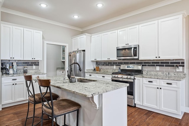 kitchen with a kitchen island with sink, white cabinets, and stainless steel appliances