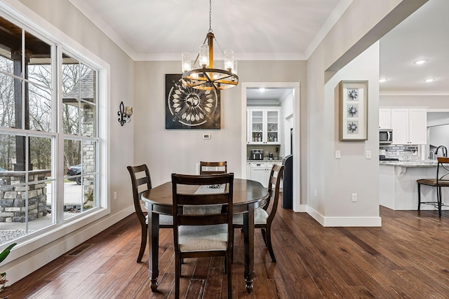 dining room featuring crown molding, dark wood-type flooring, and an inviting chandelier