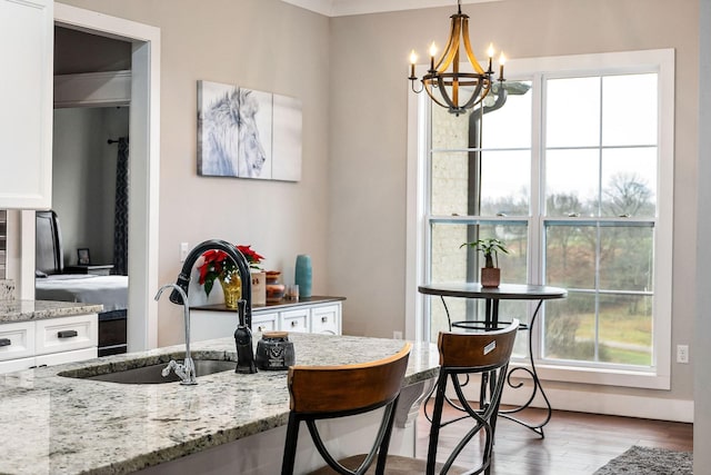 dining room featuring light wood-type flooring, sink, and an inviting chandelier