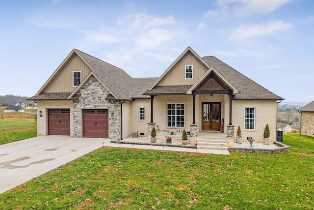 view of front of home with central air condition unit, a front lawn, a porch, and a garage