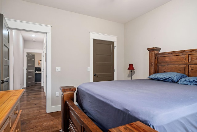 bedroom with dark hardwood / wood-style floors