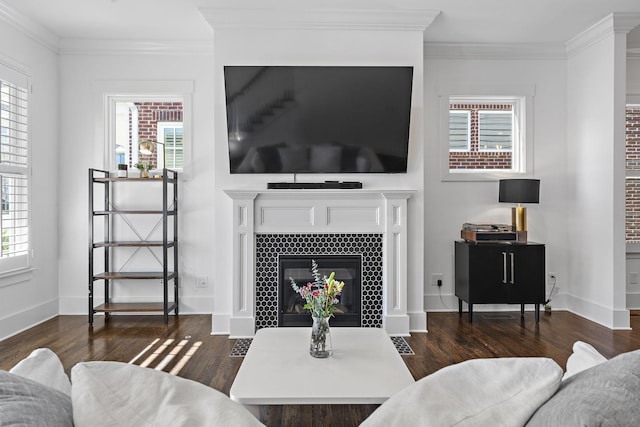 living room featuring a tile fireplace, dark hardwood / wood-style floors, and ornamental molding