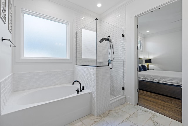 bathroom featuring crown molding and separate shower and tub