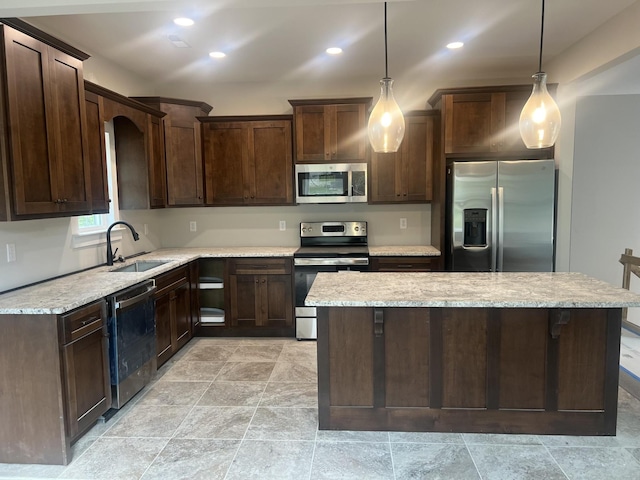 kitchen with sink, stainless steel appliances, decorative light fixtures, and dark brown cabinetry