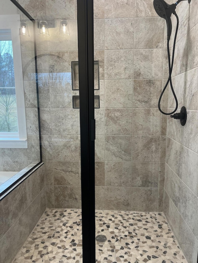 bathroom with a tile shower and a wealth of natural light