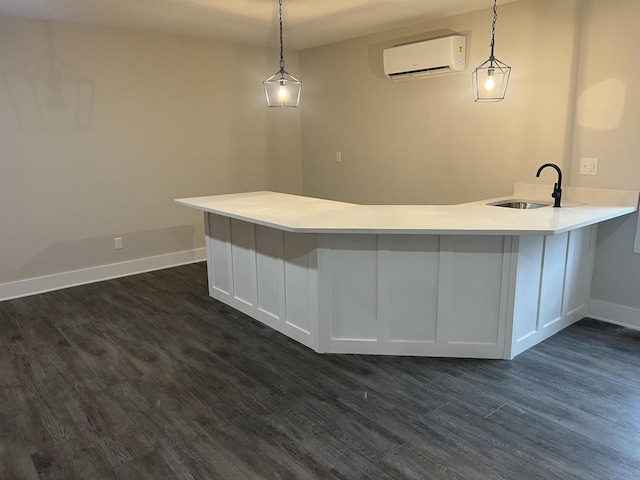 kitchen with sink, decorative light fixtures, an AC wall unit, and white cabinets