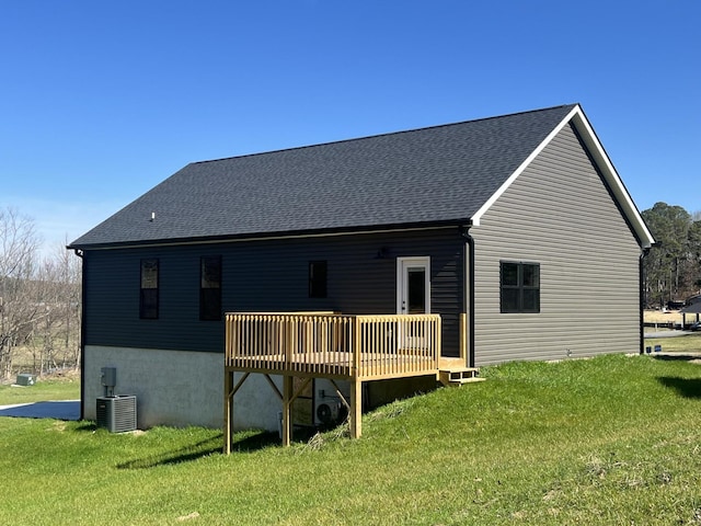 back of property with a wooden deck, a yard, and central air condition unit