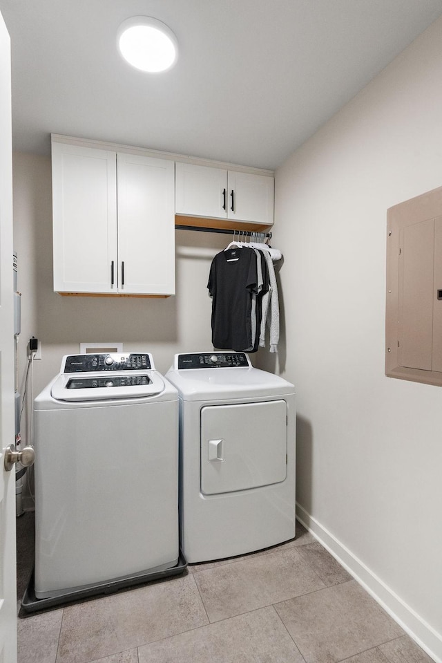 clothes washing area with light tile patterned floors, cabinets, separate washer and dryer, and electric panel