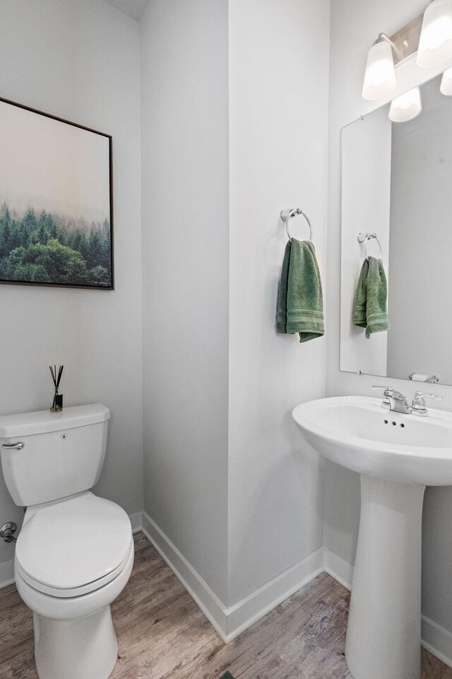 bathroom with sink, toilet, and hardwood / wood-style flooring