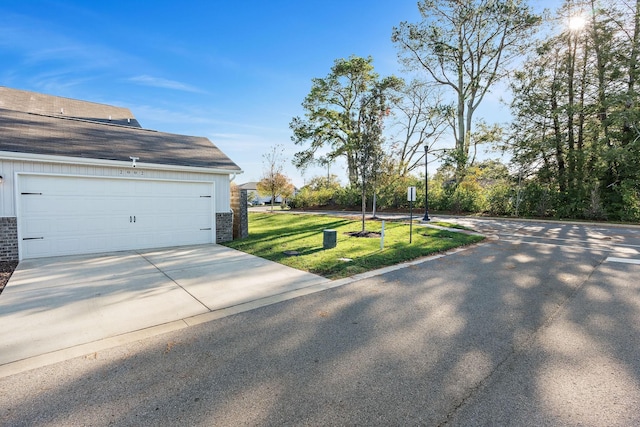 view of property exterior with a yard and a garage