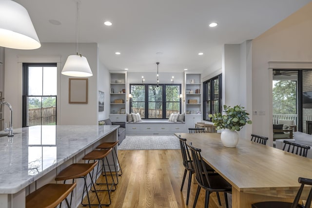 dining area featuring sink, built in features, and light wood-type flooring