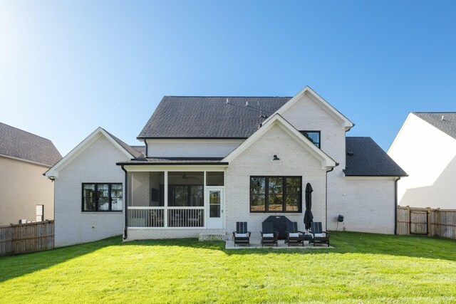 rear view of property featuring a yard, outdoor lounge area, a patio area, and a sunroom