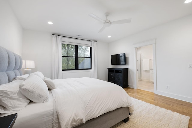 bedroom featuring light hardwood / wood-style flooring, ceiling fan, and ensuite bath