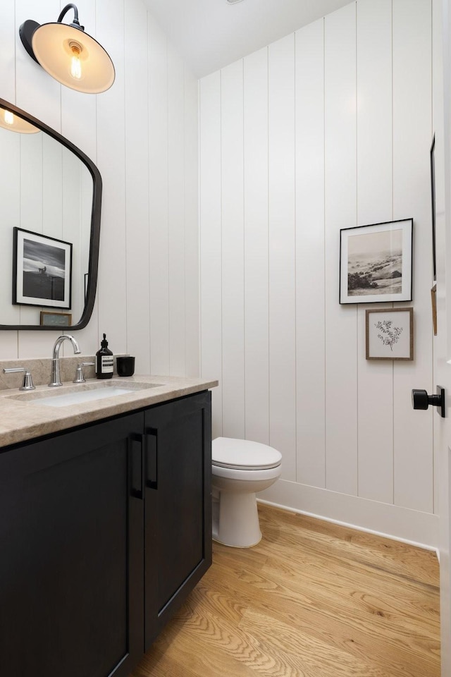 bathroom featuring vanity, hardwood / wood-style floors, and toilet