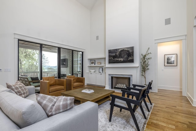 living room featuring light hardwood / wood-style flooring and a high ceiling