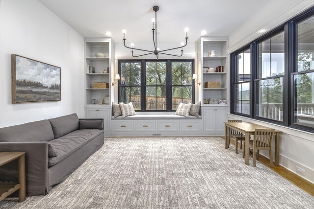 interior space with an inviting chandelier, built in features, and light hardwood / wood-style floors