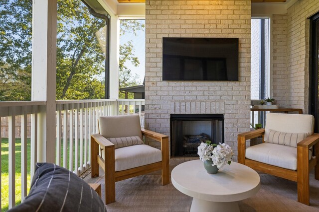 sunroom featuring a brick fireplace