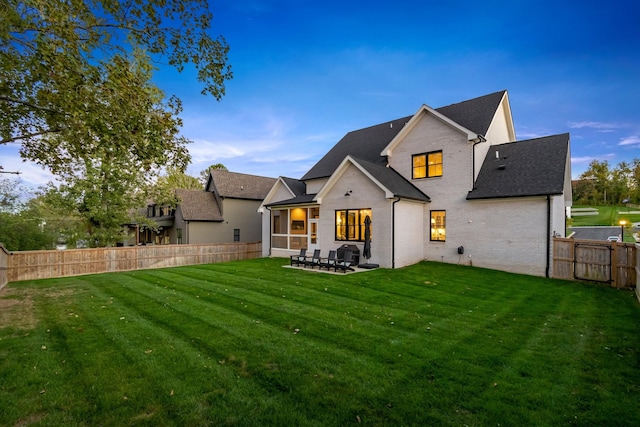 back of property with a yard and a patio