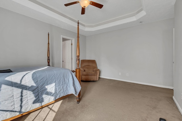 carpeted bedroom featuring ceiling fan and a tray ceiling