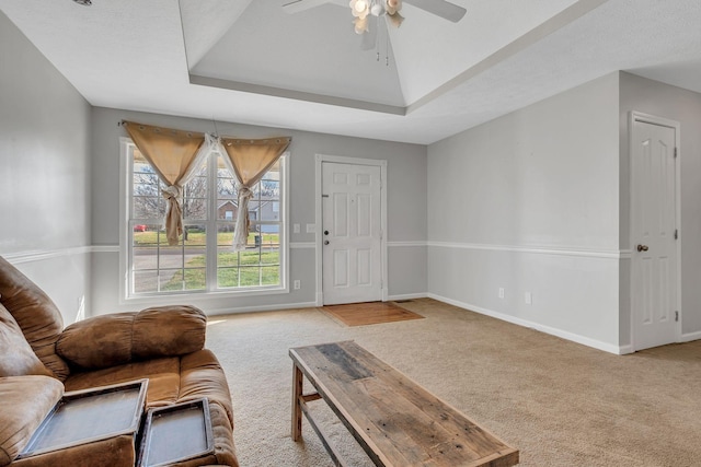 carpeted living room featuring ceiling fan and a raised ceiling