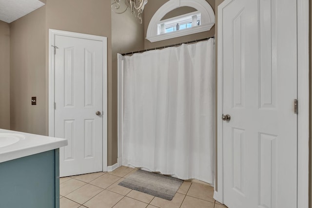 bathroom featuring tile patterned flooring, vanity, and a chandelier