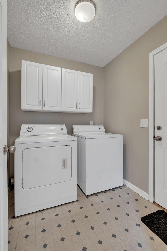 laundry room with cabinets, separate washer and dryer, and a textured ceiling