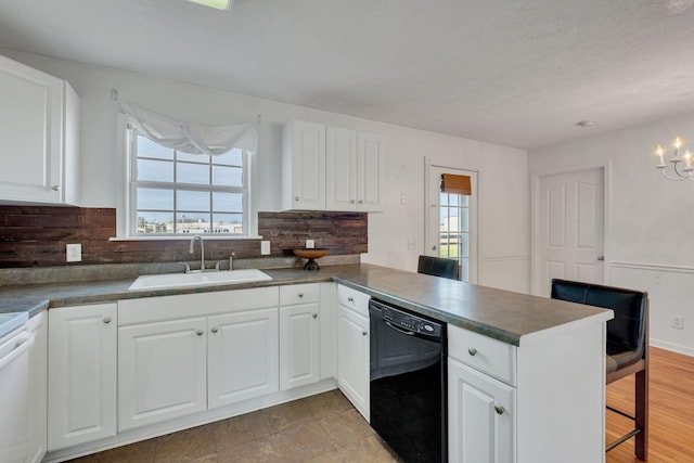 kitchen with dishwasher, white cabinets, and sink