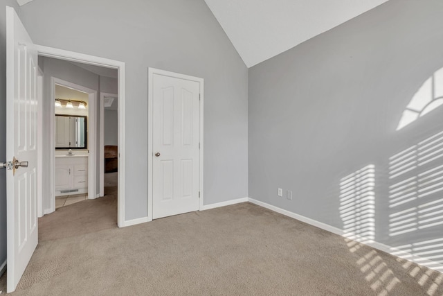 unfurnished bedroom featuring light colored carpet and vaulted ceiling