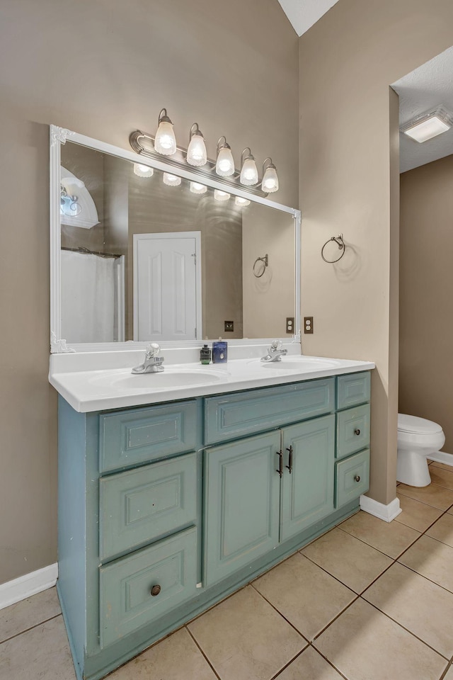 bathroom featuring toilet, a shower with curtain, vanity, and tile patterned floors