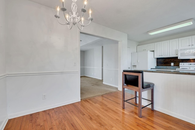 kitchen featuring decorative backsplash, white appliances, a notable chandelier, white cabinets, and light hardwood / wood-style floors